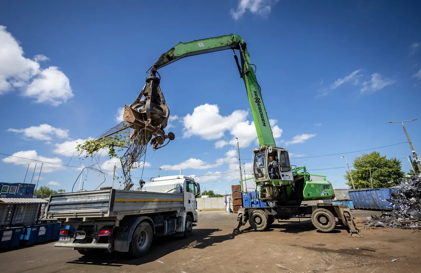 Excavator dismantling an industrial steel structure during demolition